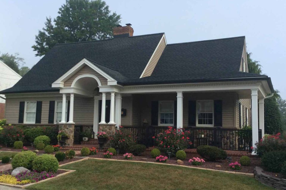 Dark architectural shingle roof on a cottage with a columned porch