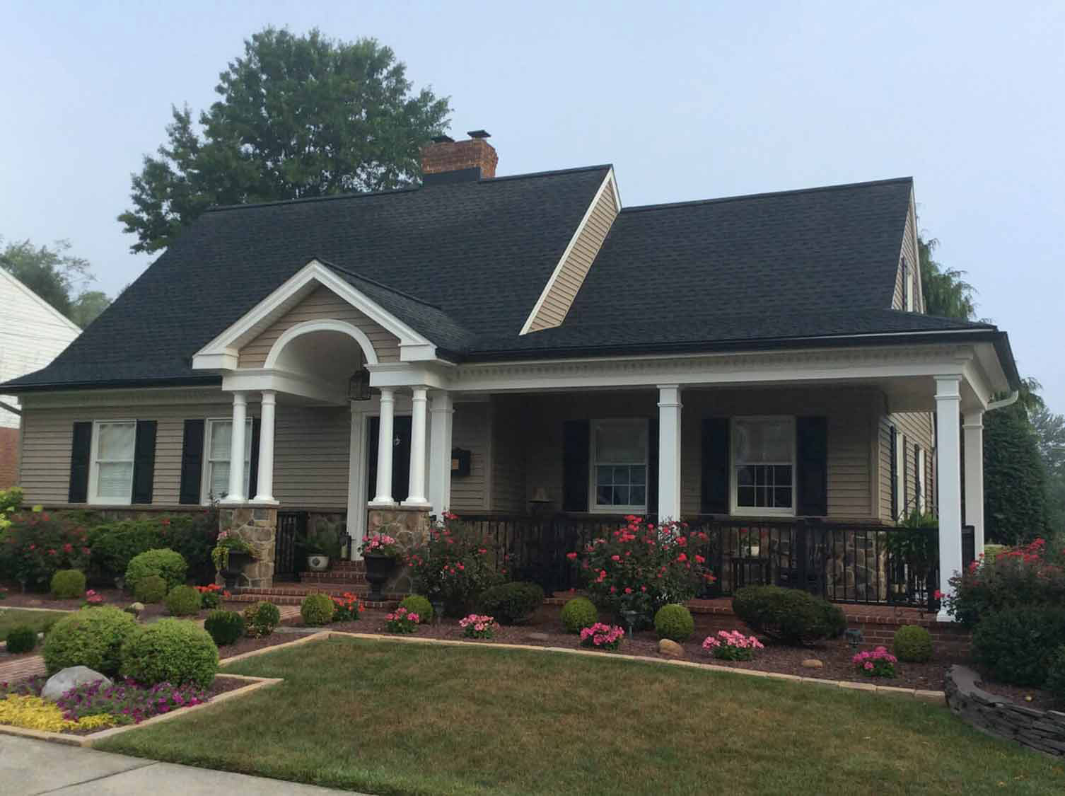 Dark architectural shingle roof on a cottage with a columned porch