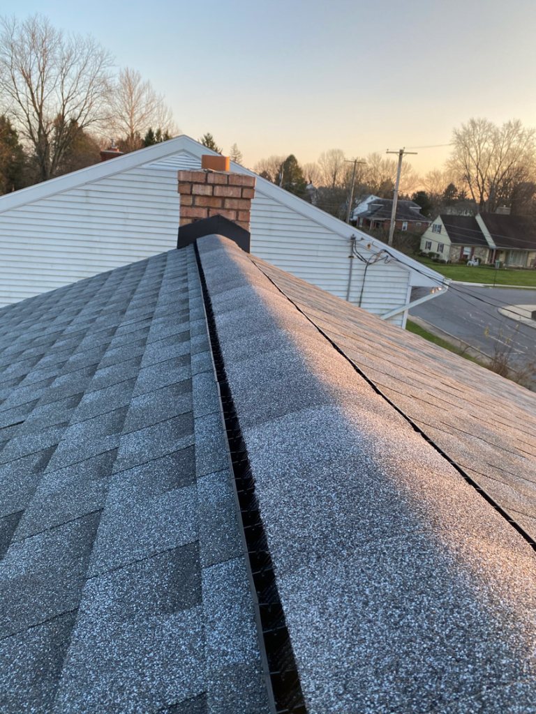Close-up of new shingles and a ridge vent at sunset